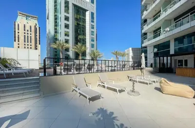 a patio with benches and tables in a building at StoneTree - Botanica Tower 1 BR - Close to Beach in Dubai