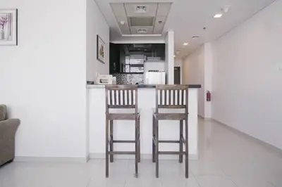 two wooden stools sitting at a counter in a kitchen at StoneTree - Botanica Tower 1 BR - Close to Beach in Dubai