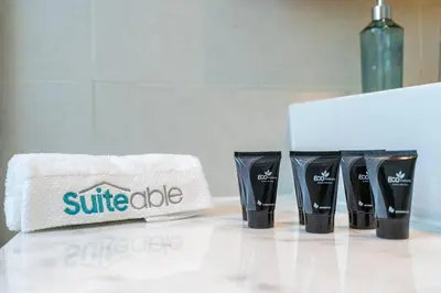 a white counter with three black cups and a white towel at Sophisticated Business Bay Canal View by Suiteable in Dubai