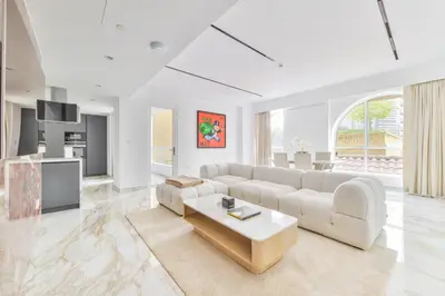 a white living room with a couch and a table at Stunning 1BR in Bahar near JBR Beach in Dubai