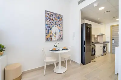 a kitchen with a table and chairs in a room at Marina & Downtown Views in Modern Studio - JVC in Dubai