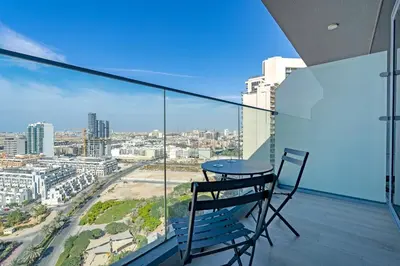 a chair on a balcony with a view of a city at Marina & Downtown Views in Modern Studio - JVC in Dubai